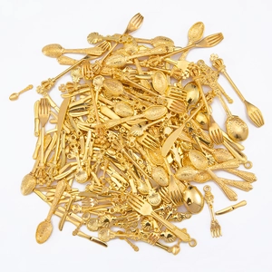 Macro shot of vintage gold cutlery charms with detailed European floral relief patterns