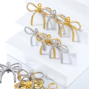 Primer plano de colgantes de lazo con diamantes de imitación en oro y plata para joyas