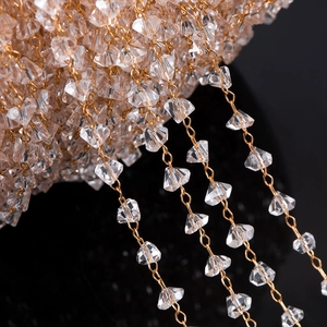 Macro-opname van transparante kristallen kralen op gouden koperen ketting voor DIY-sieraden