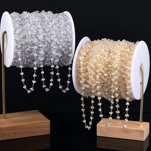 Detail van DIY sieradenketting met heldere driehoekige kristallen op goud en zilver