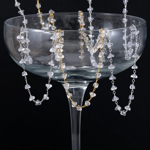 Detail van DIY sieradenketting met heldere kristallen op een glas met kunstlicht