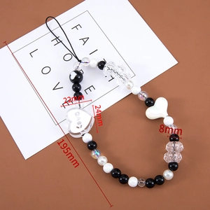 Detail view of 195mm beaded phone strap with black, white, and heart-shaped charms