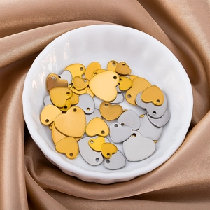 Macro shot of heart-shaped stainless steel charms in gold and silver for DIY jewelry