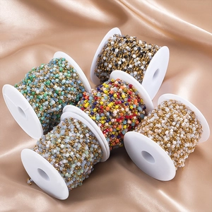 Detail of colorful square beads and gold metal spacers on jewelry chains for DIY crafting