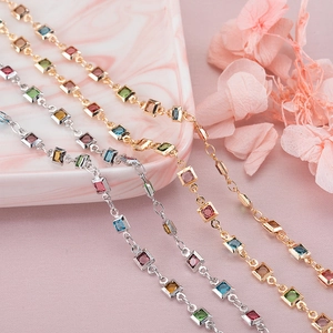 Detalle de piedras de circón cuadradas de colores en finas pulseras de oro y plata