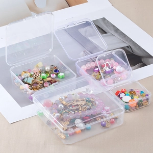 Macro shot of assorted transparent PP organizer boxes filled with jewelry and beads