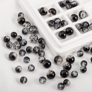 Macro detail of 10mm black and silver crackle glass beads for DIY jewelry making