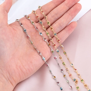 Primer plano de elegantes pulseras de oro y plata con piedras preciosas cuadradas de colores