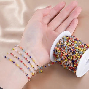 Macro detail of colorful beaded chain on reel for DIY jewelry making and necklace crafts