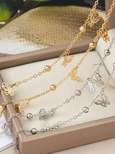 Detail of pure copper butterfly tassels and polished beads on gold and silver chains