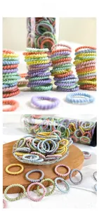 Élastiques spirales colorés pour bébés dans un bocal en plastique sur un plateau