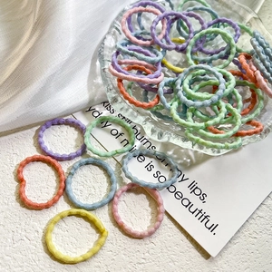 Gros plan d'élastiques à cheveux colorés sans couture à texture ondulée dans un bol
