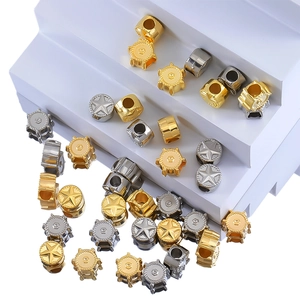 Detail of metal DIY beads featuring embossed stars and gear designs in gold and silver