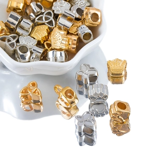 Macro shot of assorted gold and silver alloy beads with crown and butterfly designs