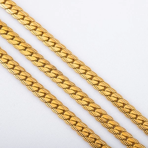 Macro view of gold-plated NK chain links with detailed diagonal stripe engraving