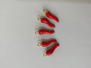 Detail of five red chili pepper charms with gold rings for DIY jewelry making