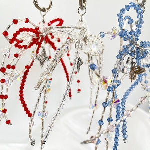 Close-up of handmade acrylic crystal beaded bow keychains in red, blue, and clear colors