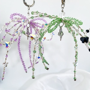 Macro shot of handmade beaded dragonfly keychain with crystal beads and metal star charms