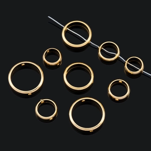 Makroansicht von goldfarbenen Edelstahl-Ringverbindern mit Seitenlöchern für DIY-Schmuck