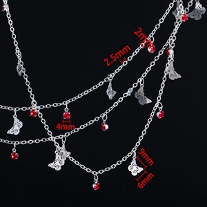 Detailed macro view of silver butterfly charms and red crystal rhinestones on link chains