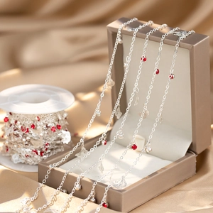 Silver butterfly necklace with red rhinestones draped over a luxury jewelry gift box