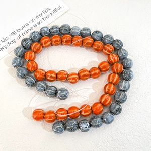 Close-up of glossy orange and mottled blue ceramic beads for DIY jewelry making