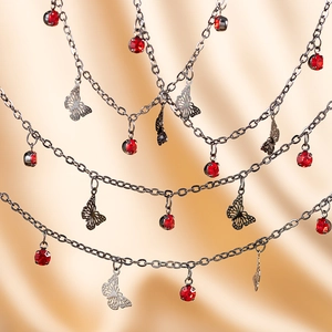 Detail showing copper butterfly charms and red crystal rhinestones on multilayered chains