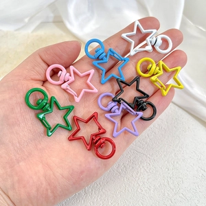 Detailed macro view of colorful star-shaped alloy lobster clasps held in a palm