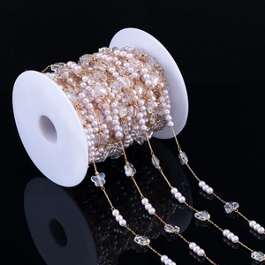 Close-up of golden pearl butterfly chain for DIY jewelry making on white spool