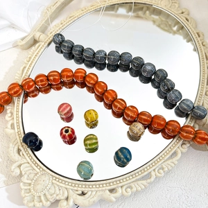 Detailed close-up of pumpkin-shaped ceramic beads with vintage fluted texture and glazed finish