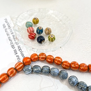 Macro shot of pumpkin-shaped striped ceramic beads for DIY jewelry making and crafts