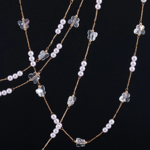 Detailed close-up of 4mm pearl and translucent butterfly charms on a gold-plated copper chain