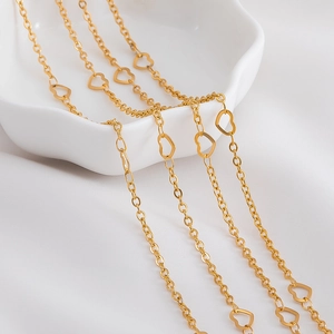 Golden heart link stainless steel chain necklace on elegant white satin and ceramic tray