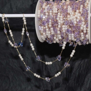 Detail of DIY pearl chain with purple crystal butterflies on a golden metal wire link