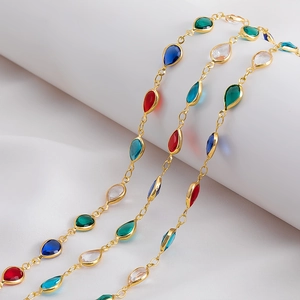 Close-up of multicolored teardrop glass crystals with gold frames on a jewelry chain