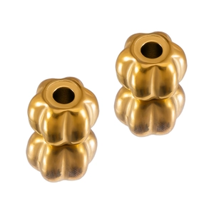 Detailed macro view of two golden petal shaped spacer beads for DIY jewelry making