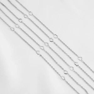 Detailed macro of stainless steel link chains with delicate hollow heart-shaped charms