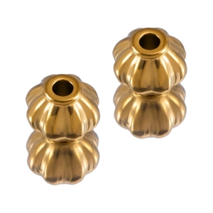 Macro detail of golden pumpkin-shaped stainless steel spacer beads with reflective finish
