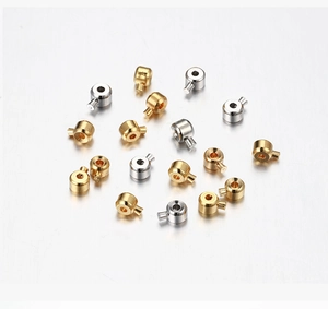 Dettaglio macro di perline cilindriche in metallo oro e argento per creazione gioielli DIY