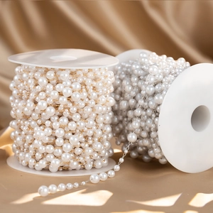 Detail of gold and silver pearl chain rolls on elegant champagne satin for DIY jewelry