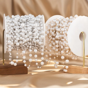 Detail view of white pearl chain rolls with gold and silver metal links for DIY jewelry