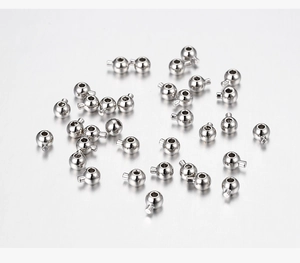 Dettaglio dei grani di posizionamento in metallo argentato per bracciali DIY