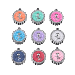 Macro shot of colorful resin pendants with metal rose relief and vintage lace borders