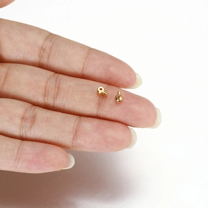 Perline a schiacciare dorate per bracciali DIY tenute in mano per mostrare la misura