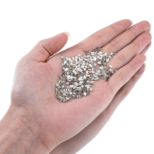 Détail de paillettes à ongles métalliques argentées en forme de losange en main
