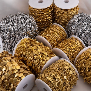 Close-up of gold and silver butterfly and teardrop charms on DIY stainless steel chains