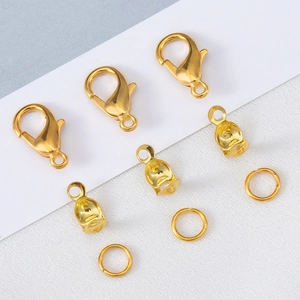 Close-up of golden lobster clasps, jump rings and fold-over cord ends for DIY jewelry