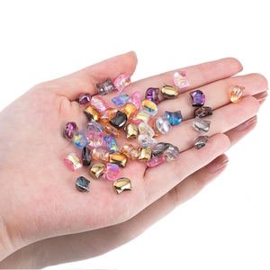 Iridescent glass cat head beads for DIY jewelry making shown in hand on white background