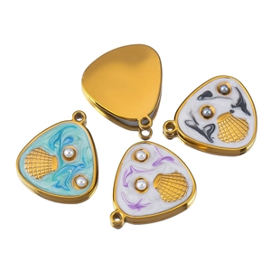 Macro shot of seashell charms with colorful enamel textures and faux pearls for jewelry DIY