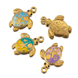 Macro view of gold ocean turtle pendants with colorful enamel shell and sea motifs